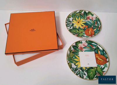 une boîte orange et deux assiettes ornées de fleurs, posées sur une table