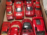 a lot of red toy cars in a cardboard box