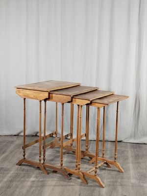 trois tables en bois posées sur un parquet, à côté d'un rideau blanc
