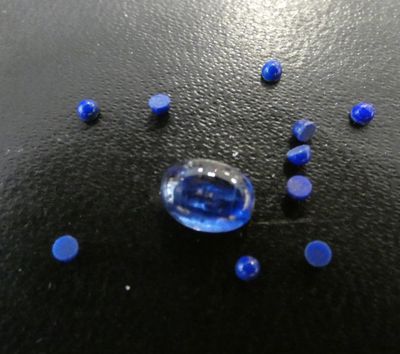 a close up of a blue glass object on a black surface