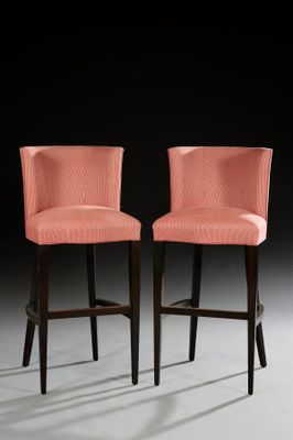pair of pink upholstered bar stools with black legs