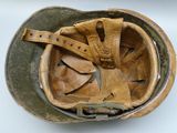 an old helmet with a leather strap is on a white surface
