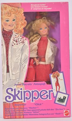 la boîte d'une poupée Barbie aux cheveux blonds et vêtue d'une veste blanche