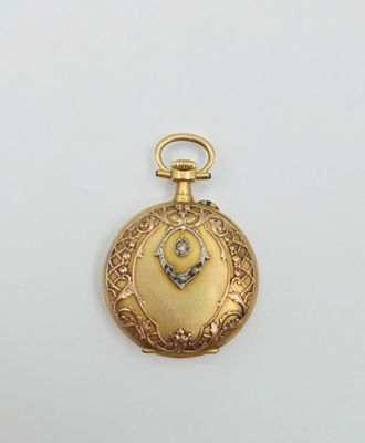 une image représentant une montre de poche en or ornée d'un diamant au centre