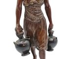 bronze statue of a woman with pots and pans on a stand