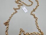 a gold chain necklace with a heart charm on it