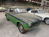 two old cars that are parked in a garage
