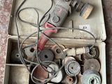 une boîte remplie d'outils divers posée par terre