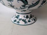 a white bowl with a green and black design on it