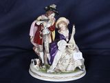 une figurine représentant un homme et une femme assis sur un banc