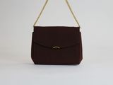 un sac à main marron dont la poignée est ornée d'une chaîne dorée