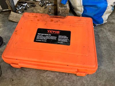 une boîte orange posée par terre à côté d'un vélo