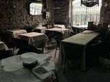 des tables et des chaises dans un restaurant avec un mur en pierre
