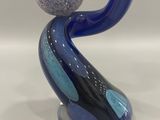blue and black glass sculpture with a ball on top of it