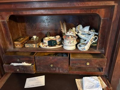 une petite armoire en bois sur laquelle sont posés de nombreux objets