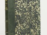 un livre à la couverture verte posé sur une table blanche