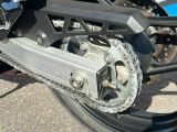 un gros plan sur la chaîne de la moto, à l'avant de celle-ci