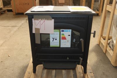 a black stove sitting on a pallet in a warehouse