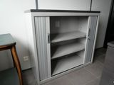 a white cabinet with shelves and a table in the corner