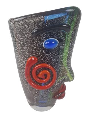un vase noir orné d'un visage rouge et bleu