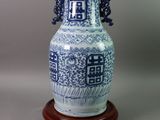 a blue and white vase on a wooden stand