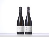 two bottles of wine sitting on top of a table next to each other