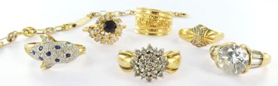 many different types of rings and bracelets on a white surface