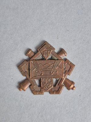 une photo d'une petite épingle en bronze sur laquelle figure l'effigie d'un homme