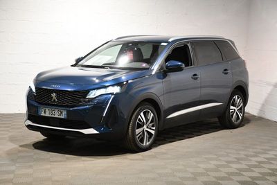 Un SUV bleu est garé dans une pièce au sol carrelé.