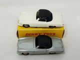 two toy cars sitting next to each other on a table