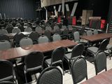 tables and chairs in a large room with a stage in the background