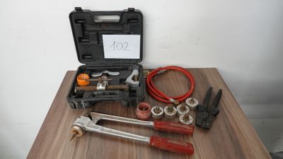 une boîte à outils posée sur une table, sur laquelle est accrochée une pancarte