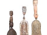 three old bells are sitting next to each other on a white surface