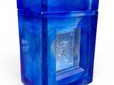 a blue glass box with a silver plate inside of it