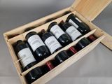 bottles of wine are in a wooden box on a table