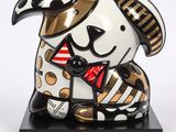 statue of a dog wearing a hat and a bow tie on a black base