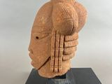 an image of a sculpture of a head on a black stand