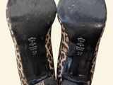 pair of leopard print high heeled shoes on a white background