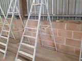 several ladders are lined up against a brick wall in a warehouse