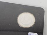 a silver coin in a plastic case with a sticker on it