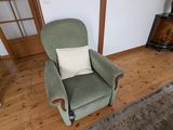 une chaise verte placée dans un salon, à côté d'une table