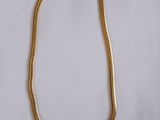 un collier en or sur fond blanc