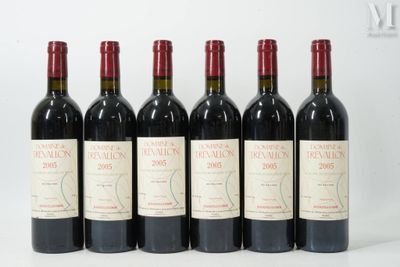 six bouteilles de vin sont alignées sur une surface blanche