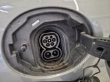 a close up of a car ' s fuel tank with a plug in it