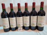 six bouteilles de vin rouge sont alignées sur une table