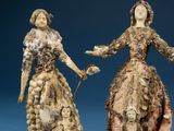 two figurines of a woman and a man holding hands