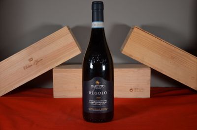 a bottle of wine sitting on a table next to a wooden box