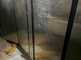 a man standing in front of a stainless steel refrigerator