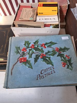une boîte de livres posée sur une table, à côté d'une pile de livres