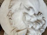 une statue représentant un homme barbu allongé sur un canapé